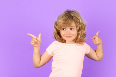 Çocuk izole edilmiş stüdyo geçmişine işaret ediyor. Kopyalama boşluğunu işaret eden işaret parmağı olan çocuk