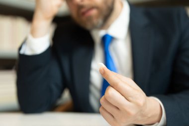 Baş ağrısı ilaçları ilaç konsepti. Baş ağrısından ilaç alan bir adamın portresini yakından çek..