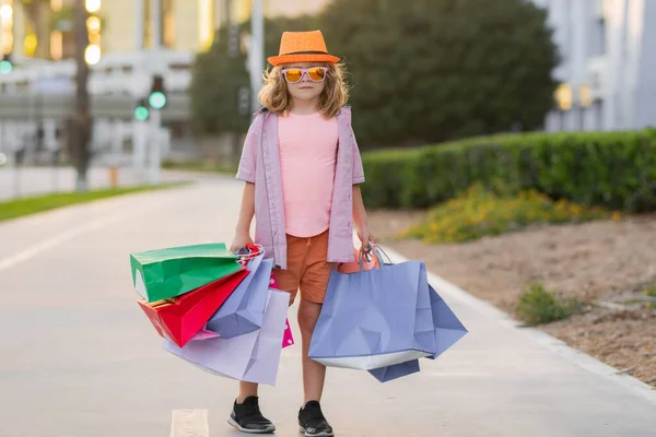 Child with shopping bags. Fashion and sale