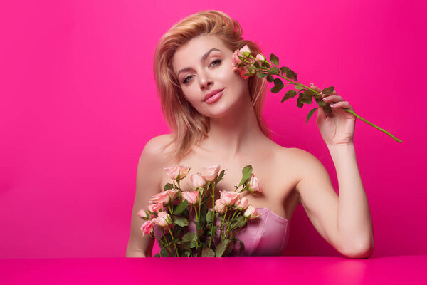 Beauty studio portrait. Beautiful model with pink rose flower, isolated on pink studio background. Charming young girl with perfect makeup