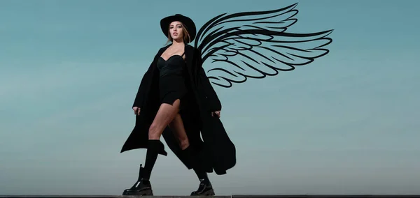 Sensual woman angel with wings. Valentines day panoramic photo banner. Fashion woman in black fashion coat, hat and black shoes boots