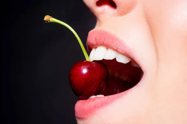 樱桃在牙齿 关闭了 樱桃在女人嘴里 漂亮的女孩 嘴里含着樱桃 女人唇上的樱桃女孩咬樱桃 — 图库照片