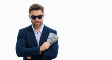 Takım elbiseli ve parası olan bir adam. Dolar banknotları. Amerikan banknotlarını tutan adamın portresi. Dolar, kredi, internet bankacılığı. Zengin adam dolar banknotlarını, banka kredilerini, mali tasarrufları gösteriyor