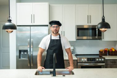 Yemek pişirme ve aşçılık konsepti. Mutfakta üniformalı aşçı. Erkek aşçı ya da önlüklü aşçı. Aşçının bereli portresi. Yemek pişirme konsepti