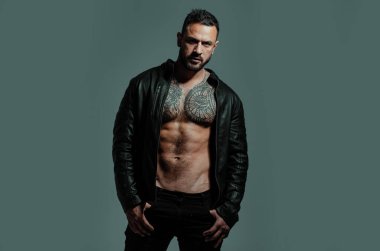 Üstsüz maço adam. Acımasız adamın moda portresi. Güçlü kaslı erkek vücudu, kaslı adam. Seksi bir adam. Moda erkek modeli, moda tarzı.