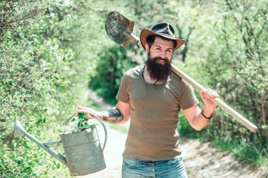 Organik çiftçi ol. Kürek ve su dolu bir çiftçi.