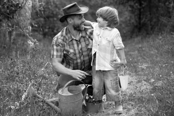 父亲和儿子在自然界与浇灌罐 园艺工具 爸爸教小儿子照看植物 花园里的小帮手让地球变得更绿种植植物 照顾好植物 — 图库照片