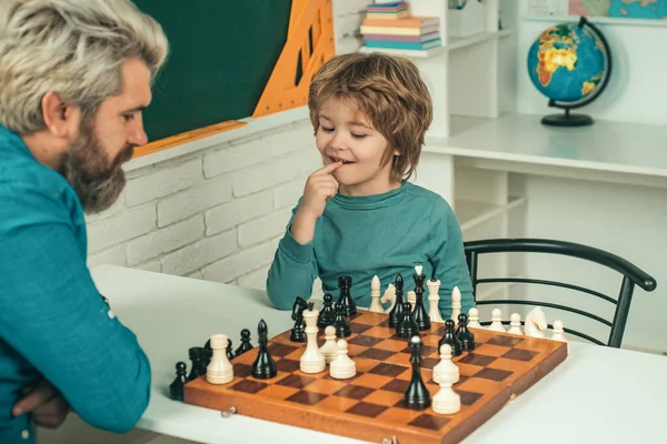 可爱的小男孩和父亲下棋 英俊的老师给学龄前男孩上私下里的象棋 回学校去父子俩快乐 — 图库照片