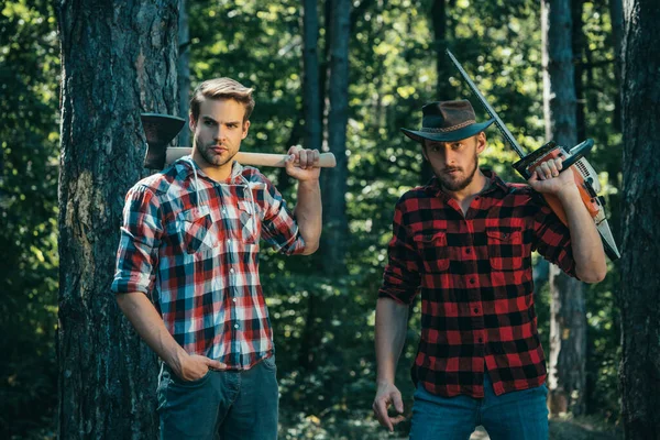 체크무늬 셔츠를 배경에 도끼를 벌목꾼 작업자들 — 스톡 사진