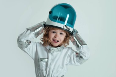 Miğferi rüya gibi görünen küçük astronotun yakın plan yüzü. Uzay kıyafetli küçük çocuk kameraya gülümsüyor. Sevimli küçük astronot çocuk.