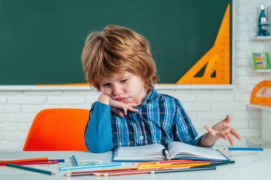 Çocuk bilimi eğitimi konsepti. Komik yüzlü, sevimli bir öğrenci. Evde eğitim. Çalışmaya biraz hazır. Okuldaki küçük çocuklar.