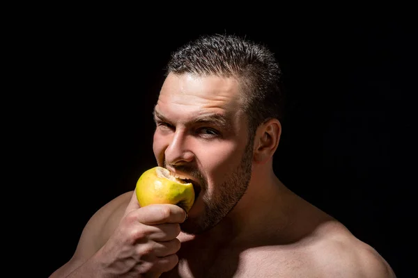 リンゴを持ってる人 スタジオの背景に隔離されたリンゴを食べる男の肖像画 天然ビタミン 健康的なライフスタイルのための健康的なリンゴ果実 強い男のスタジオの肖像 緑のリンゴを食べる — ストック写真