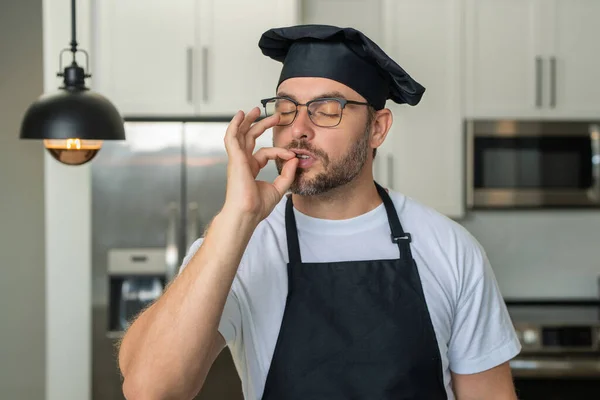 Man chef cooker, baker. Male chefs with sign of perfect food. Chef cooking, showing sign for delicious. Chef, cook making tasty delicious gesture by kissing fingers. Chefs cook in hat and apron kiss