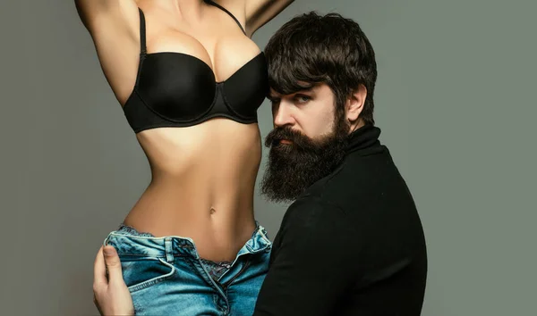 Serious hipster touches a female body. Tender picture of young couple. Sexy moments. Young beautiful couple in love. Sensual couple. Young couple posing in studio