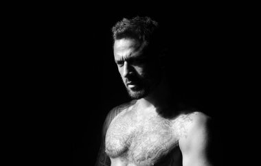 Acımasız bir adam, yakışıklı erkek modelin ciddi yüzü, erkek gücü kavramı ve güçlü. Kaslı atletik seksi erkek, çıplak gövde.