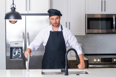 Aşçı aşçı adam. Milenyum aşçı üniformalı erkek şef. Aşçı mutfakta yemek pişiriyor. Aşçı şapkalı ve önlüklü
