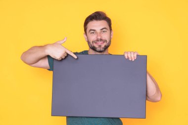 Bilgi konsepti. Boş pankartlı bir adam. Metnin ya da tasarımın için kopyalama alanı gösteriliyor. Stüdyo arka planında boş reklam panosu gösteren bir adam. Boş pano, reklam tabelası.