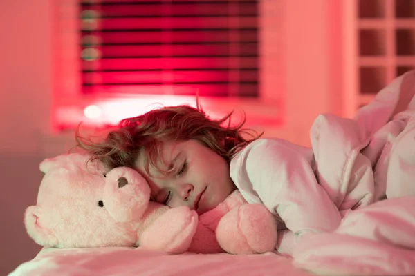Sleep, sleeping concept. Child sleeping in bed with a toy teddy bear. Cute kid sleeping under blanket. Kid lying on pillow. Child rest asleep, enjoy healthy sleep or nap