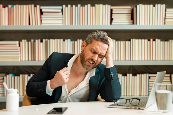 疲労とストレス スーツのビジネスマンは ラップトップを使用して 疲れている頭痛片頭痛を得た 頭痛の痛みの概念 職場では苦痛な男達が強調される ストレスと頭痛の種 — ストック写真