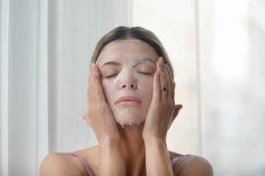 Yüz maskeli kadın. Kozmetik prosedürü. Güzellik kaplıcası ve kozmetoloji. Yüz kilinden maske takan spa kadını, yakın plan. Güzellik tedavileri