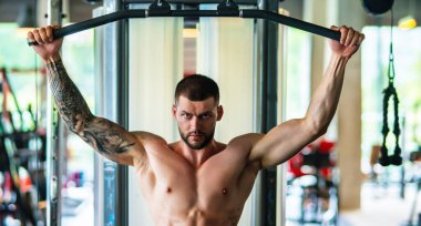 Man exercising with dumbbell. Male bodybuilder doing weight lifting workout at gym. Training with barbell. Muscled man strong muscular fit man workout with heavy weight. Exercises for muscular body