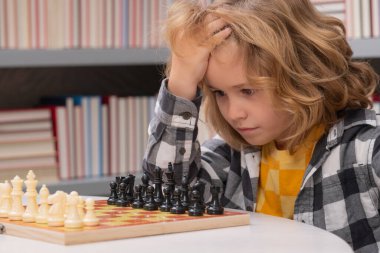 Satranç, başarı ve kazanma. Satrancı düşünen çocuk. Öğrenme ve çocuk yetiştirme kavramı. Satranç, başarı ve kazanmak. Mantık oyunu, çocukların hobisi ve yaşam tarzı