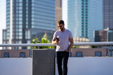 Şehirde kendine güvenen yakışıklı bir adamın portresi. Modern büyük Amerikan şehrinde kendine güvenen bir adamın portresi. Şık bir Lambersex modeli. Polo giymiş seksi bir adam. Moda erkeği Tampa 'da sokakta poz veriyor.