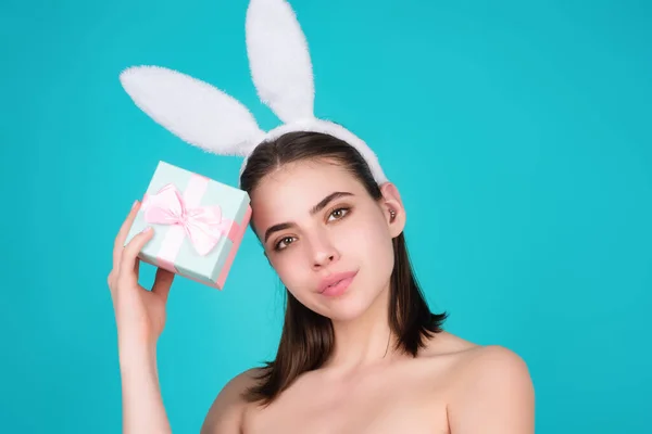 Portrait of young woman wearing bunny ears holding easter eggs over isolated background in studio. Beautiful woman with rabbit ears hold easter egg, studio shot isolated background