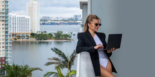Sexy confident businesswoman in fashion business suit using laptop in Miami