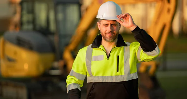 建筑工地的工人 用硬礼帽做的 戴头盔的建筑工人带头盔的建筑工人 建筑业的工人 用挖掘机在工地建造的建筑 — 图库照片