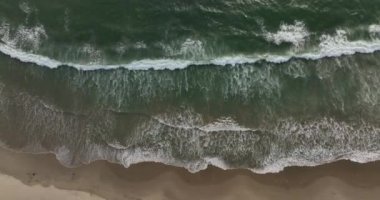 Aerial view top view drone move Beautiful topical beach. Top view beach. Drone view of sea waves breaking on sandy coastline. Aerial shot ocean water and foamy waves