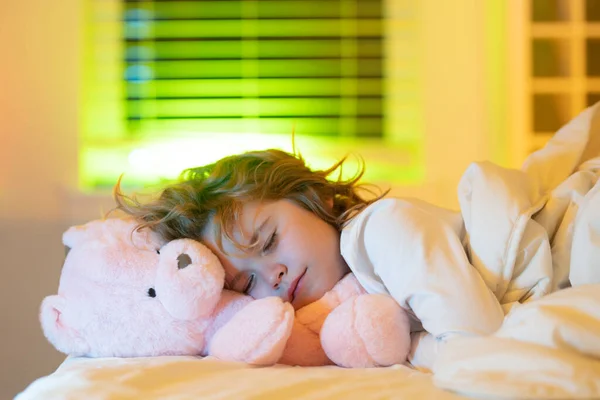 Good night sleep. Child sleep, napping. Cute kid sleeping in bed with a toy teddy bear. Sleeping kid face