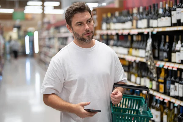 Hombre Eligiendo Botellas Alcohol Licorería Hombre Sostiene Cesta Compras Tienda —  Fotos de Stock