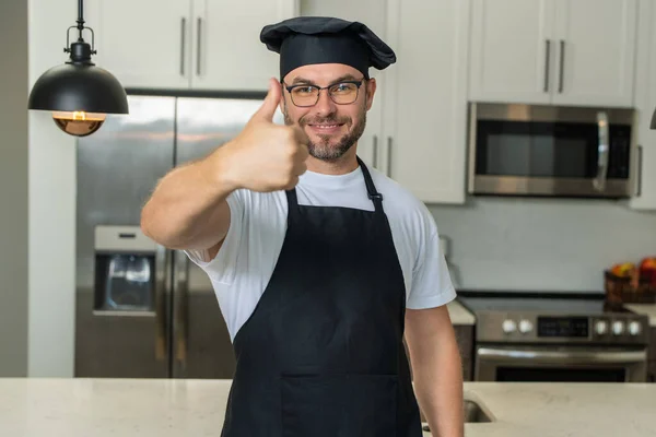 キッチンでシェフのエプロン料理の男 幸せなシェフコックとともに親指アップ — ストック写真