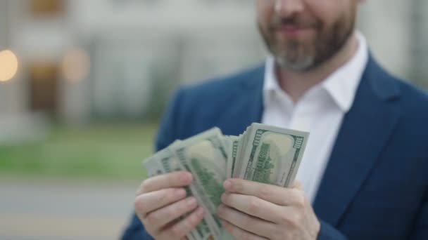 屋外でお金を数える男のスローモーション 肖像画のビジネスマンは屋外で現金ドル紙幣を保持する 幸運を祈るよバナー ドルの現金の概念 現金を獲得する喜び 財政的運と成功 — ストック動画