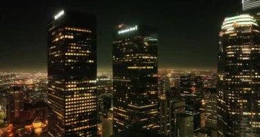 Geceleri Los Angeles 'taki gökdelenlerin manzarası. Los Angeles 'taki aydınlık binalar silueti, Los Angeles, California' daki hava aracı görüntüleri. Los Angeles 'taki Skyline kuleleri.