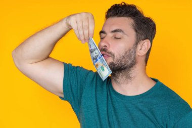 Adam sarı stüdyonun arka planına para koydu. Parası olan zengin bir adam. Dolar banknotları olan başarılı bir adam. Zengin milyoner.