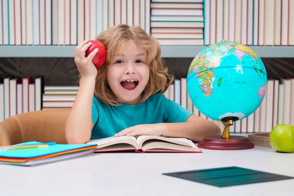 図書館で本とリンゴを持つ学校の少年 小学生の子供 学校用品を持つオタク学生の肖像 — ストック写真