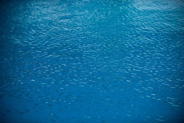 太陽の反射とスイミングプールでリップル水 波状の水の背景 — ストック写真