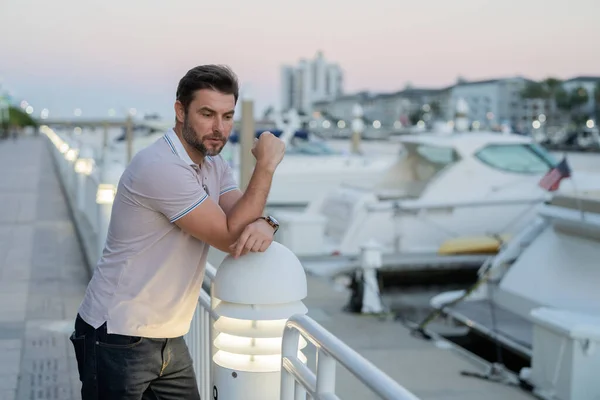 stock image Rich businessman dreaming and thinking near the yacht. Successful male model in big city living the urban lifestyle. Young male fashion model walking in street. Young hispanic man at the street