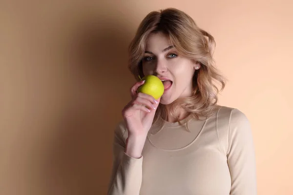 アップルのコンセプトを噛んだ ベージュ地の上に隔離されたリンゴを食べる若い女性の肖像画 天然ビタミンのための健康的なリンゴの果物 食事やビーガン スタジオの肖像画の美しさの女の子食べる緑 — ストック写真
