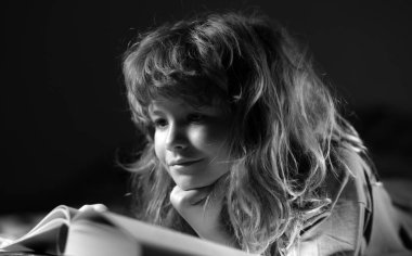 Hild Kitap 'ın yakın plan portresi. Küçük çocuk oturma odasında kitap okudu hikaye kitabındaki resimleri izledi. İlkokul için ödev yapan bir çocuk. Çocuklar çalışır