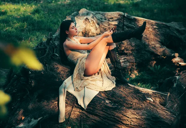 成年妇女坐在公园的木头上很放松 性感模特 皮肤光滑 穿着短裙化妆 年轻女子摆姿势 具有自然妆容的漂亮模特的肖像 — 图库照片