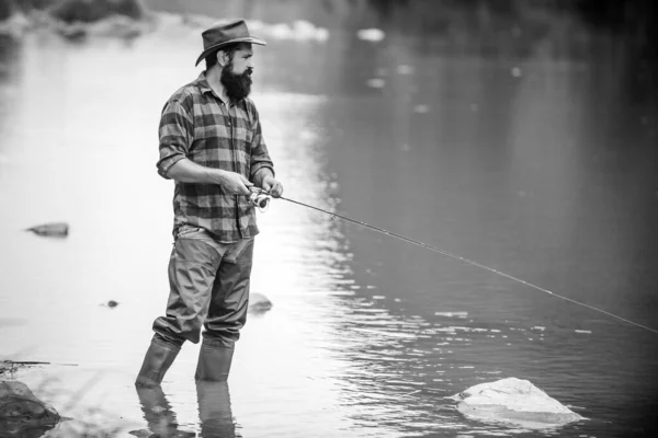 チェックされたシャツの男のフライ魚趣味 スポーツフィッシング フィッシャーは長い棒を持っている いい日だ 川で釣り 釣り人ショー釣りのテクニックはロッドを使用 — ストック写真
