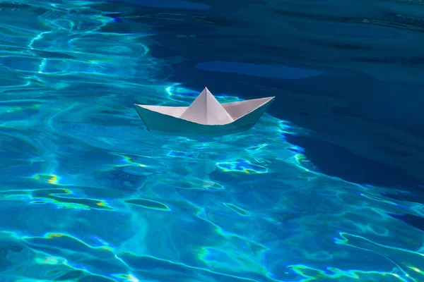 Paper ship. Paper boat in blue sea background. Tourism, travel dreams vacation holiday. Blue water background