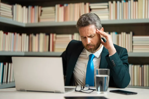 疲れた男は コンピュータの仕事の後に頭痛に苦しみ 目を閉じて頭に触れると疲れ 片頭痛を緩和する ビジネス上の問題 金融問題 危機の概念 — ストック写真