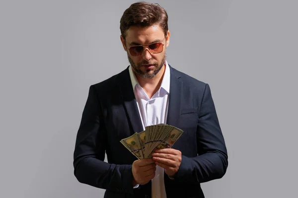 Good payment. Handsome man holding money isolated over grey studio. Money in dollar banknotes. Pile of cash, finance, investment and money saving. Mockup banner