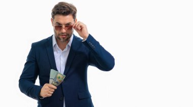 Nakit parayı dolar banknotlarıyla gösteren bir adam. Beyaz stüdyo pankartıyla izole edilmiş bir iş adamı portresi. Başarılı kazanan ya başarıyı ya da zaferi para faturalarıyla kutlar.