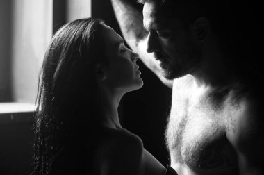 Sevimli seksi çift. Gömleksiz, kaslı bir adam öpüşen kız arkadaşını kucaklıyor. Birbirine aşık genç bir çift. Seksi, tutkulu çift kucaklaşması. Duygusal çift stüdyoda birlikte poz veriyor. Yakışıklı genç aşıklar.