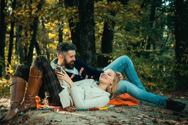 Romantic picnic forest. Couple in love tourists relaxing on picnic blanket. Romantic date in nature. Tourism concept. Couple relaxing in park together. United with nature. Valentines day concept.